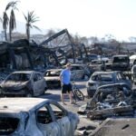 A man walks through wildfire wreckage in Lahaina, Hawaii, in 2023.